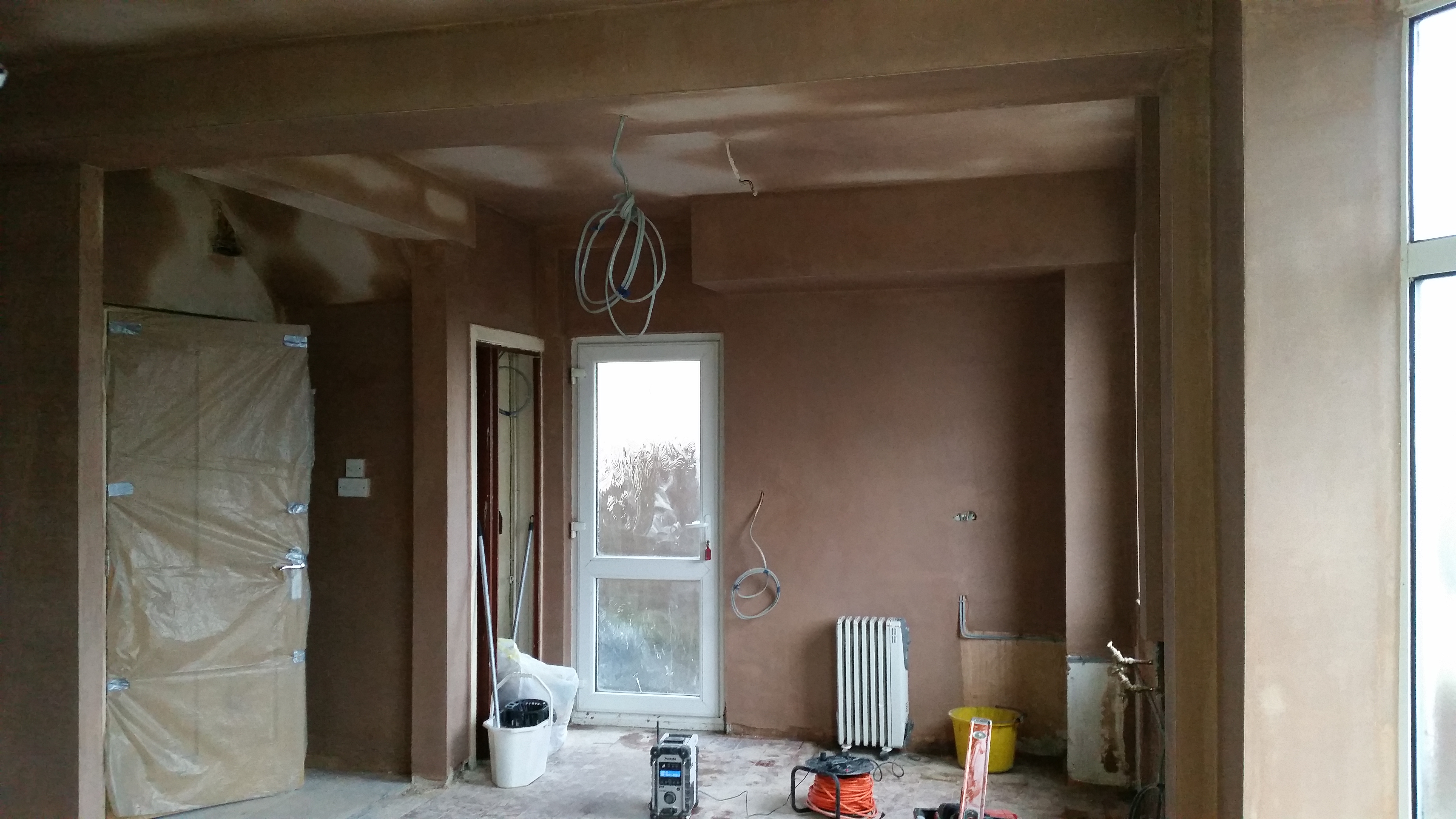 Kitchen room stripped back for installation, with unfinished walls and floor preparation