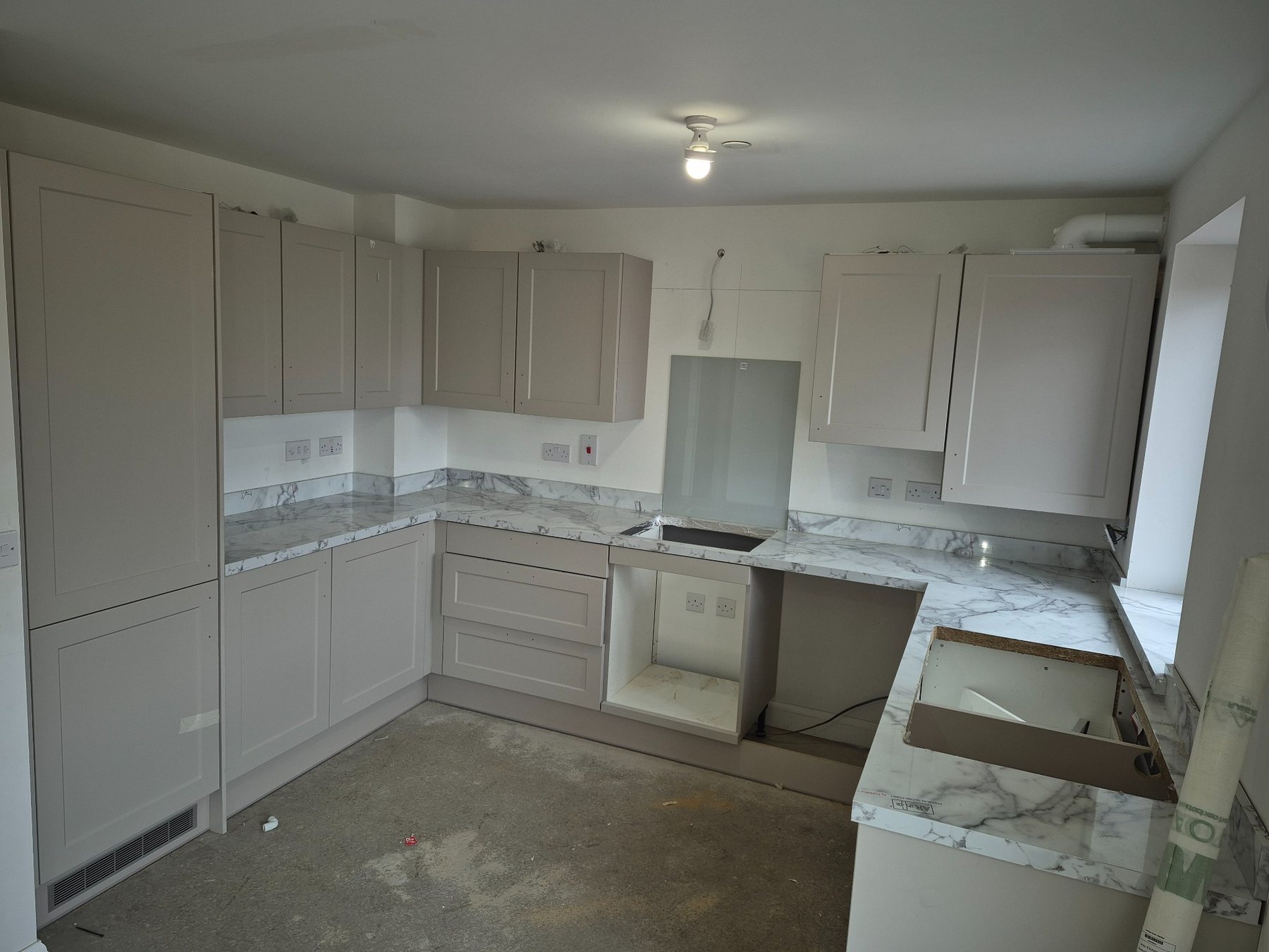 Kitchen installation in progress, with a marble worktop visible